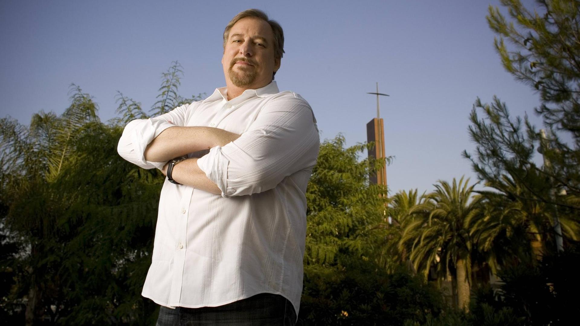 Saddleback-Church-Pastor Rick Warren steht mit verschränkten Armen vor einer Kirchenkulisse aus Kreuz und Bäumen. Saddleback-Church-Pastor Rick Warren steht mit verschränkten Armen vor einer Kirchenkulisse aus Kreuz und Bäumen.
