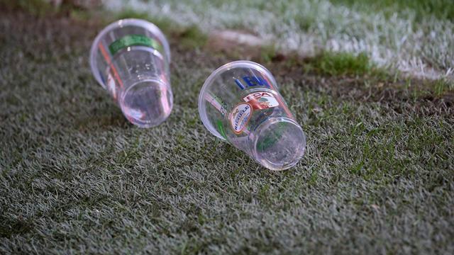 Zwei Becher liegen auf dem Rasen des Stadion in Augsburg.