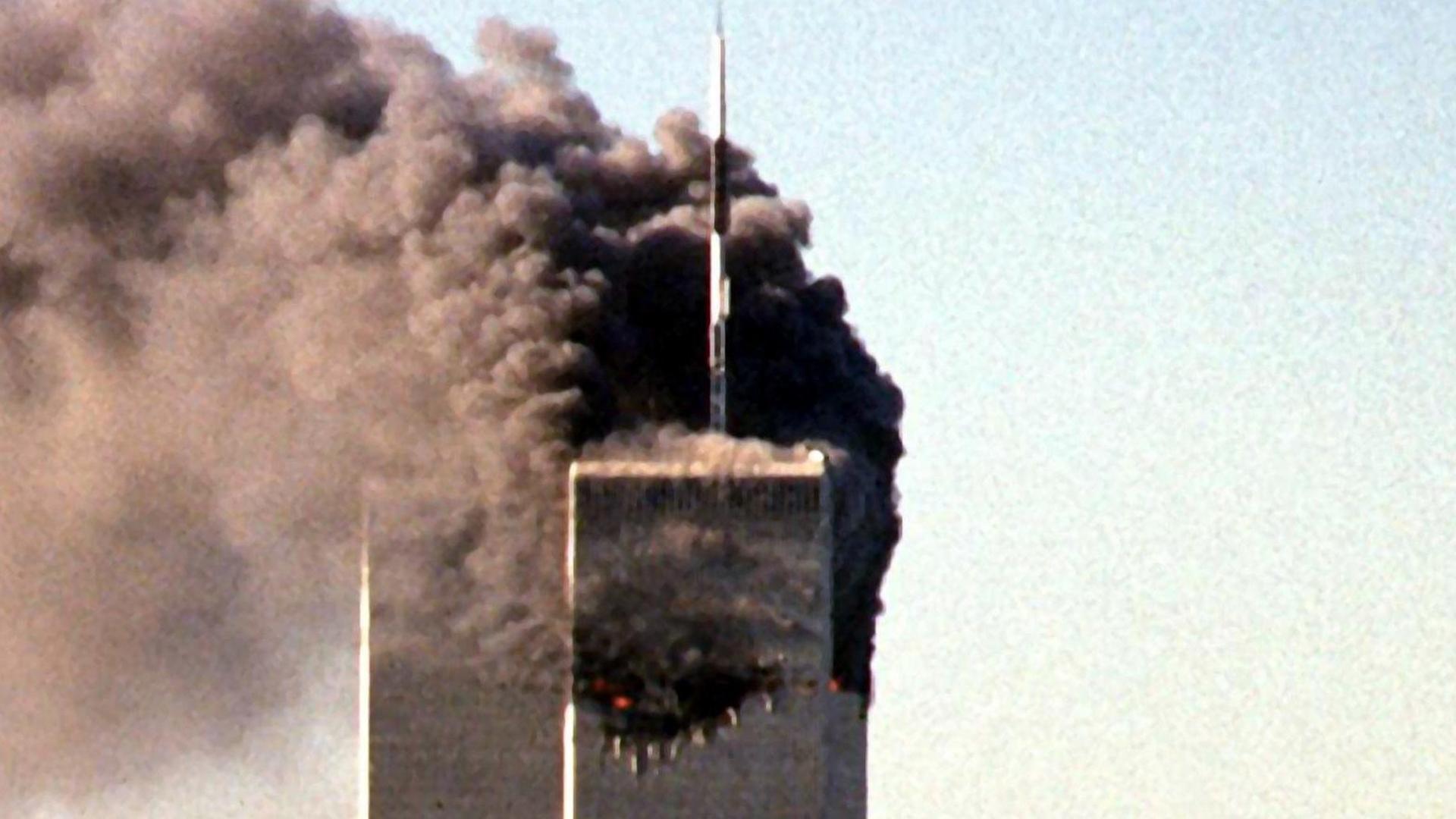 Ein Flugzeug steuert auf den zweiten Turm des World Trade Centers zu. Der erste Turm brennt bereits. Ein Flugzeug steuert auf den zweiten Turm des World Trade Centers zu. Der erste Turm brennt bereits.