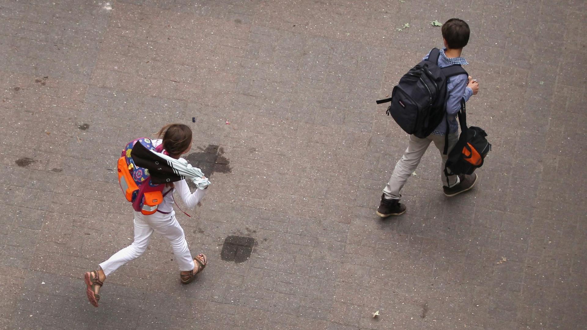 Zwei Schüler gehen über den Hof einer Schule. Zwei Schüler gehen über den Hof einer Schule.