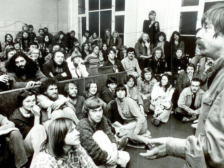 Der aus der DDR ausgebürgerte Liedermacher Wolf Biermann bei einem Solidaritätsbesuch in der besetzten Göttinger Augenklinik im Herbst 1979 mit einer Gruppe Studenten und junger Leute in einem Hörsaal.