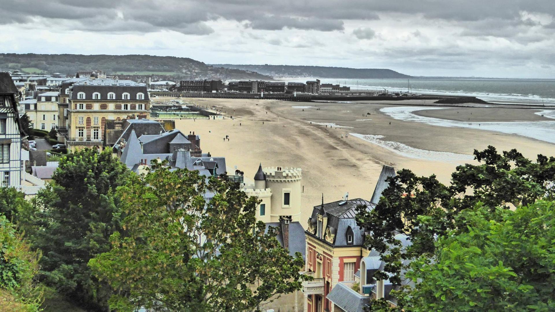 Blick auf den französischen Küstenort Trouville-sur-Mer mit Häusern, Hafen, Strand und Meer Blick auf den französischen Küstenort Trouville-sur-Mer mit Häusern, Hafen, Strand und Meer