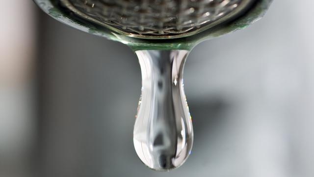 Ein Tropfen Wasser kommt aus einem Wasserhahn.