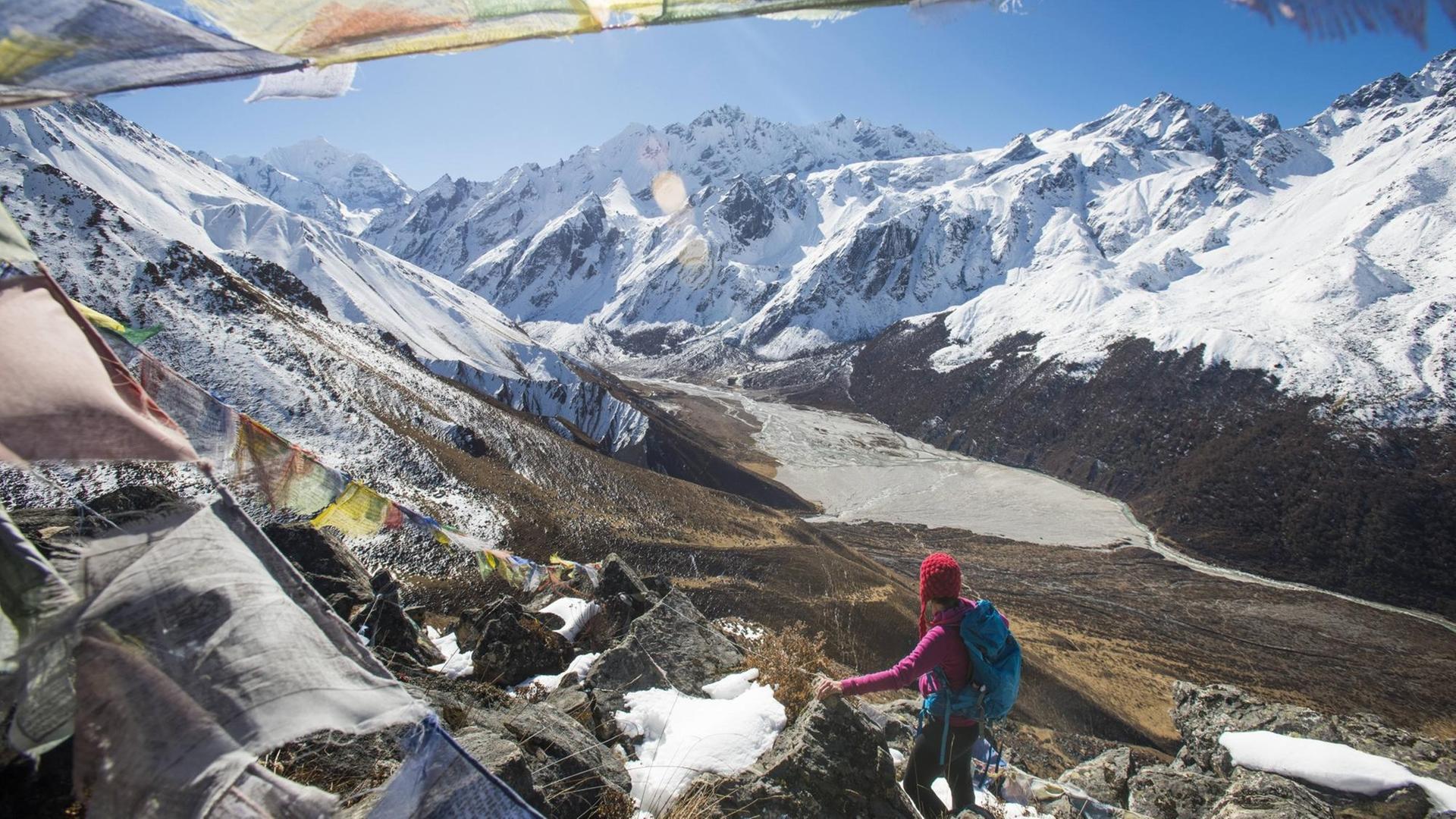 Eine Bergsteigerin steht auf der Spitze des Berges Kyanjin Ri in Nepal.
