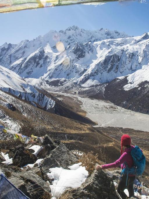 Eine Bergsteigerin steht auf der Spitze des Berges Kyanjin Ri in Nepal.