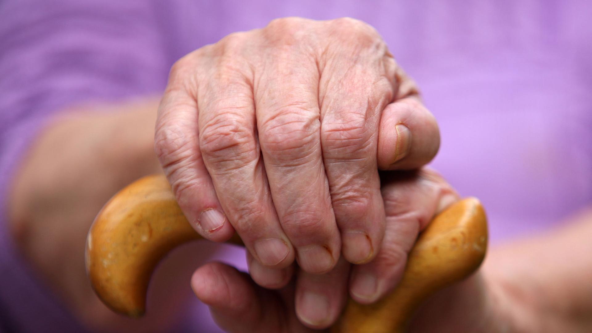 Eine Seniorin sitzt in Leichlingen mit einem Gehstock auf einer Parkbank. Eine Seniorin sitzt in Leichlingen mit einem Gehstock auf einer Parkbank.