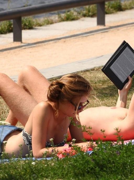 Leser mit E-Book-Reader im Park
