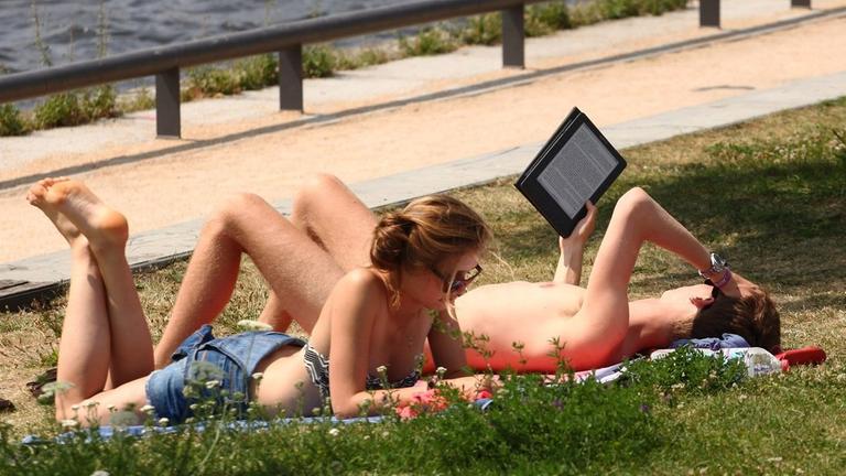 Leser mit E-Book-Reader im Park