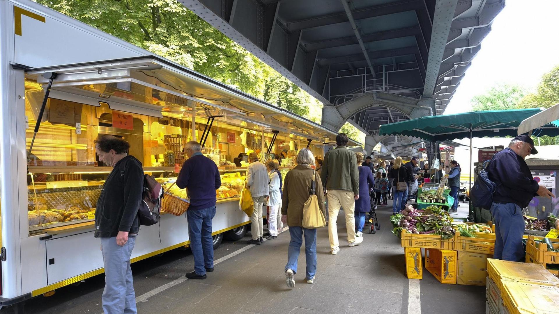 Der Isemarkt in Hamburg, der längste Wochenmarkt in Deutschland. Die U-Bahn-Gleise schützen vor Regen.