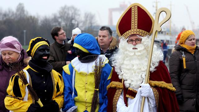 Als niederländischer Nikolaus zieht der "Sinterklaas" am 29.11.2014 vom Pier des Museumhafens auf den Weihnachtsmarkt in Emden (Niedersachsen). Begleitet wird er während seines traditionellen Besuches der deutschen Nachbarsstadt wie immer von den "Zwarten Pieten"