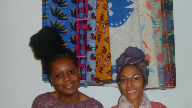 Die Designerinnen Wacy Zacarias (l.) und Djamila Machava de Sousa aus Mosambik vor ihren Capulanas - den bunt bedruckten Stoffen aus Mosambik
