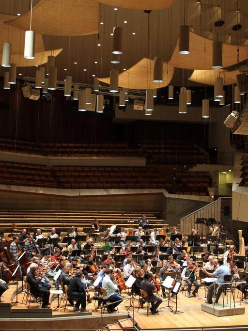 Das Orchester befindet sich auf der Bühne der Berliner Philharmonie, die Ränge sind leer.