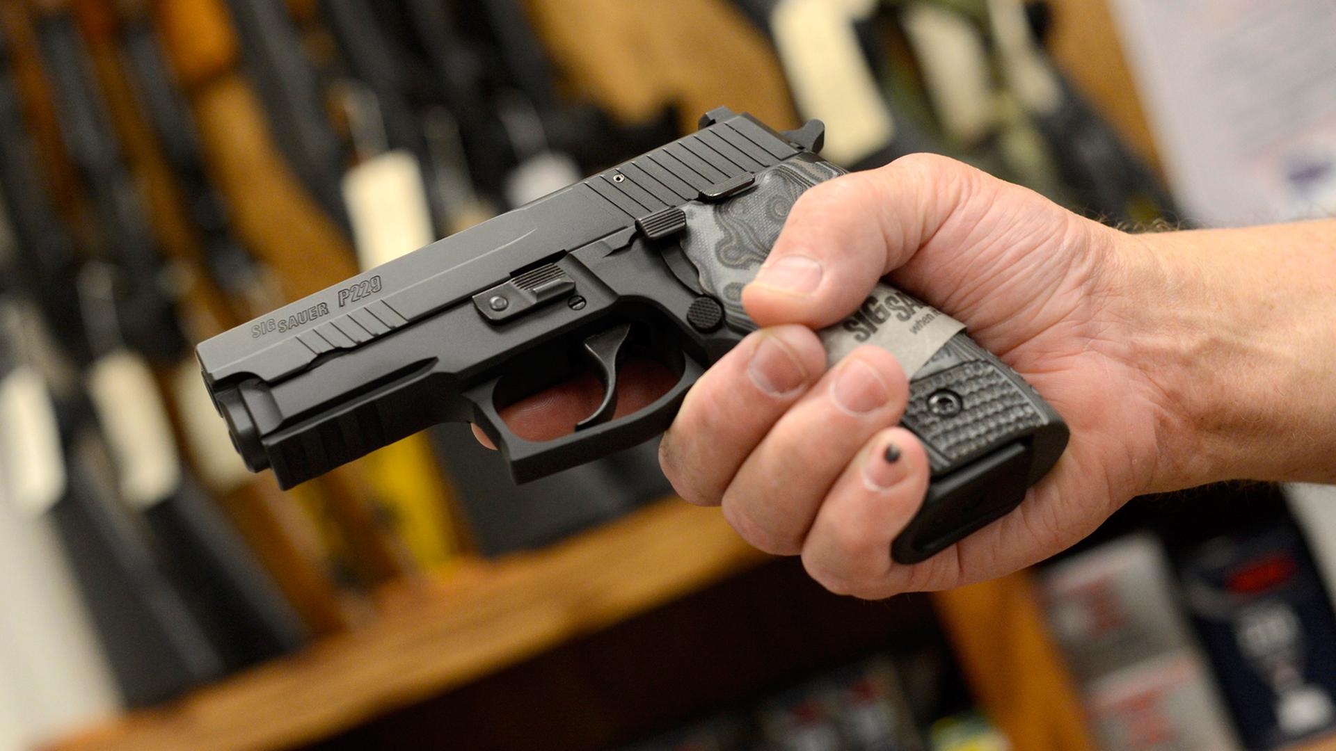 Ein Verläufer präsentiert eine Sig Sauer 9mm Pistole. Ein Verläufer präsentiert eine Sig Sauer 9mm Pistole.