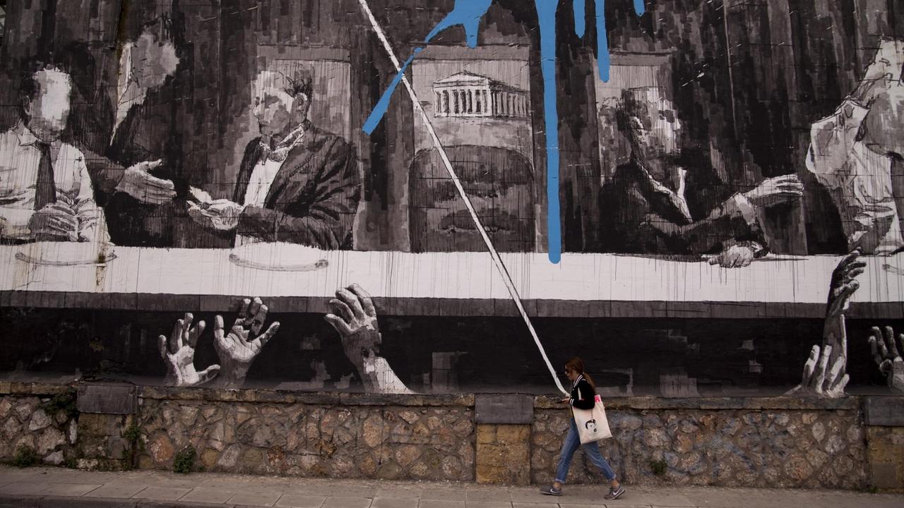 Griechin vor Wandbild "Das Abendmahl mit griechischen Politikern und der Akropolis" im Zentrum von Athen. 25.04.2019. Griechin vor Wandbild "Das Abendmahl mit griechischen Politikern und der Akropolis" im Zentrum von Athen. 25.04.2019.