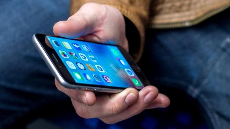 Ein junger Mann sitzt am 03.03.2017 in Frankfurt am Main (Hessen) in einer S-Bahn und benutzt dabei sein Smartphone. Ein junger Mann sitzt am 03.03.2017 in Frankfurt am Main (Hessen) in einer S-Bahn und benutzt dabei sein Smartphone.