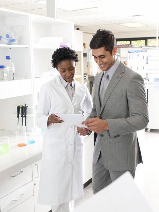 Ein Vertreter steht mit wissenschaftlichen Mitarbeitern in einem Labor.