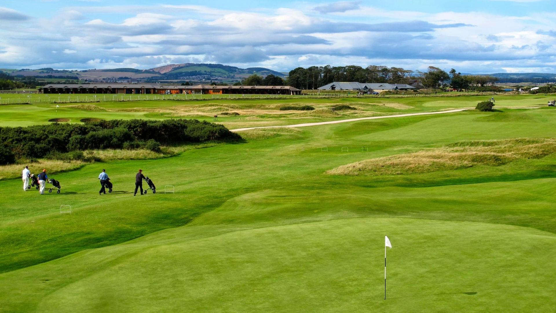 Vereinzelte Golfspieler auf dem großen grünen Jubilee Course in St. Andrews in Schottland. Vereinzelte Golfspieler auf dem großen grünen Jubilee Course in St. Andrews in Schottland.