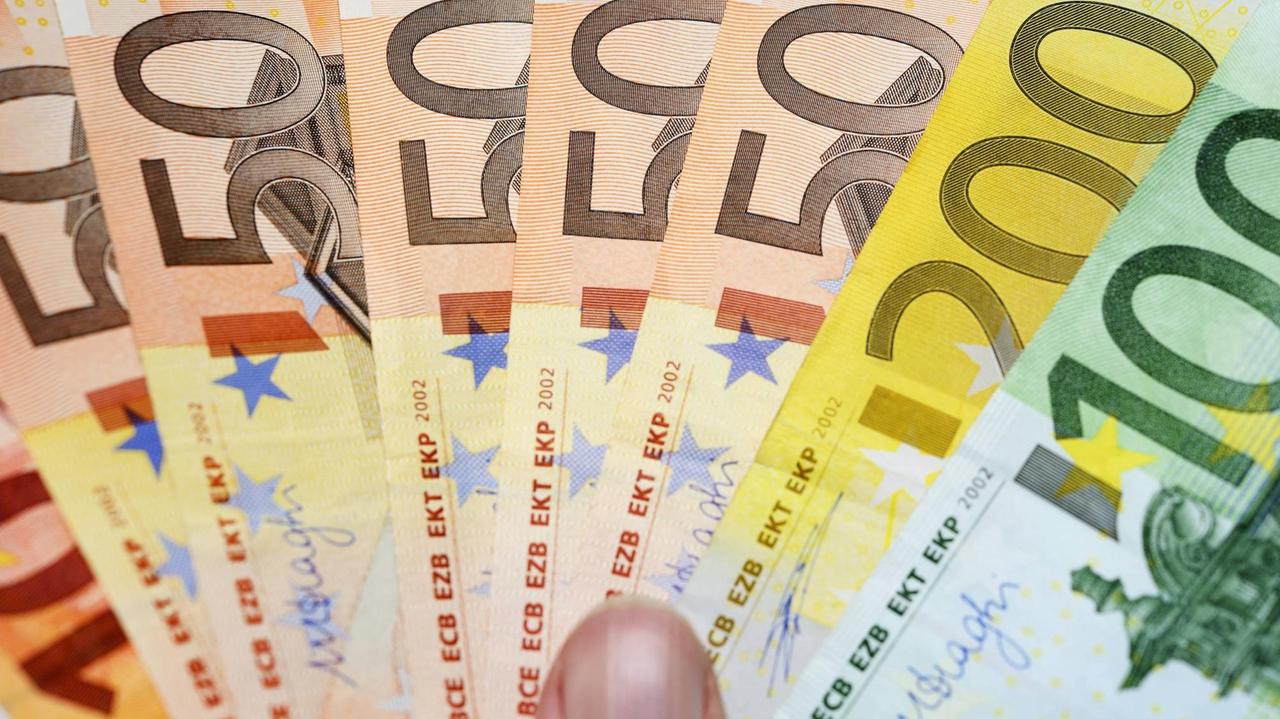 Eine Hand hält Euro-Geldscheinwie einen Fächer. | Verwendung weltweit Eine Hand hält Euro-Geldscheinwie einen Fächer. | Verwendung weltweit