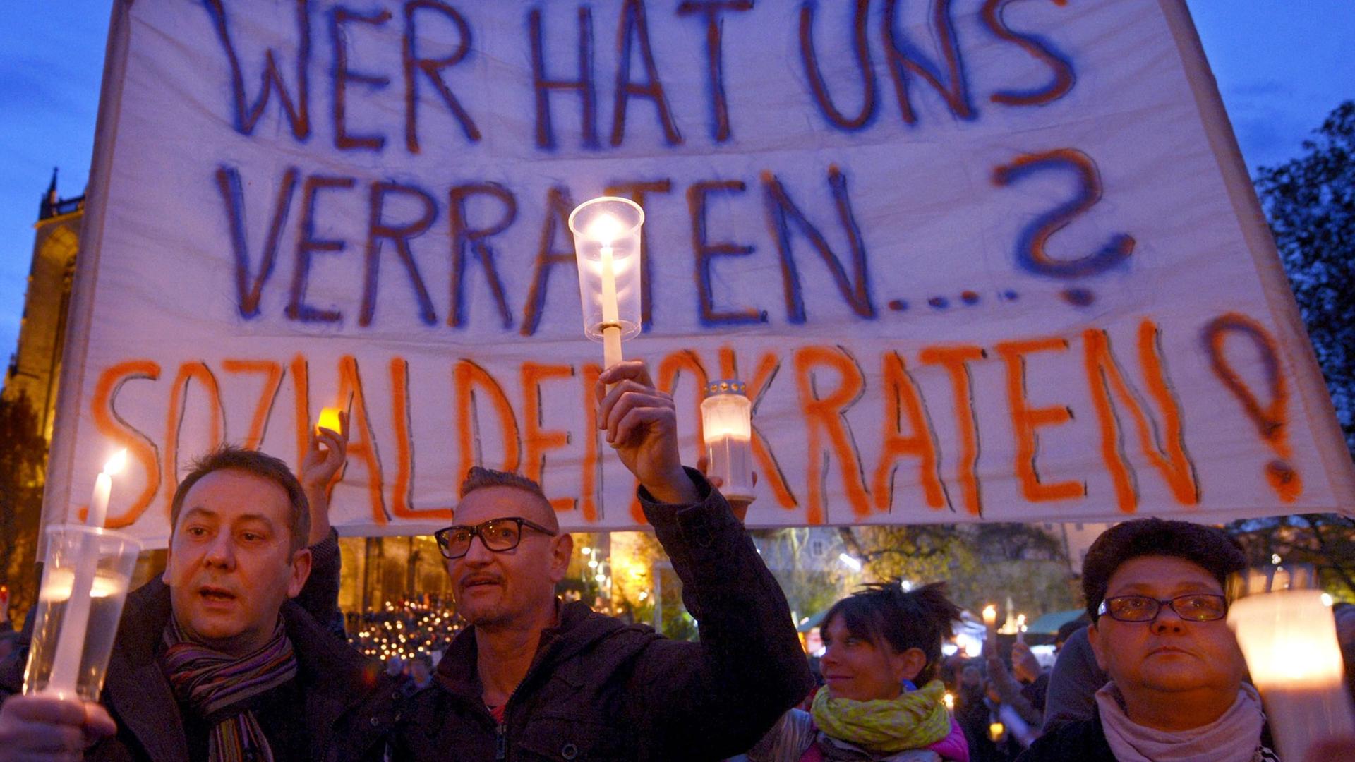 Teilnehmer einer Protestaktion gegen eine mögliche rot-rot-grüne Landesregierung in Thüringen halten auf dem Domplatz in Erfurt ein Banner mit der Aufschrift "Wer hat uns verraten...? Sozialdemokraten!" hoch. Teilnehmer einer Protestaktion gegen eine mögliche rot-rot-grüne Landesregierung in Thüringen halten auf dem Domplatz in Erfurt ein Banner mit der Aufschrift "Wer hat uns verraten...? Sozialdemokraten!" hoch.
