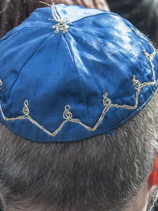 Ein Mann mit der jüdischen Kopfbedeckung Kippa sitzt am 07.05.2015 in Berlin beim Festakt zum zehnten Jahrestag der Übergabe des Denkmals für die ermordeten Juden Europas an die Öffentlichkeit.