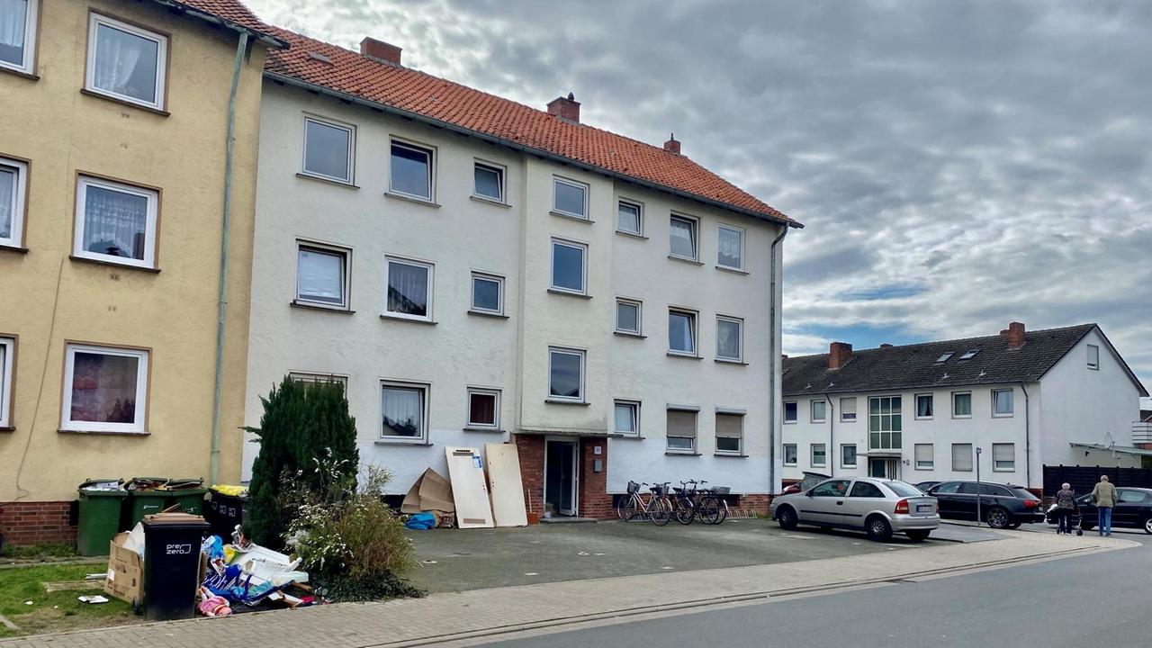Vor einem Mehrfamilienhaus stehen Mülltonnen und liegen Müllreste. Vor einem Mehrfamilienhaus stehen Mülltonnen und liegen Müllreste.