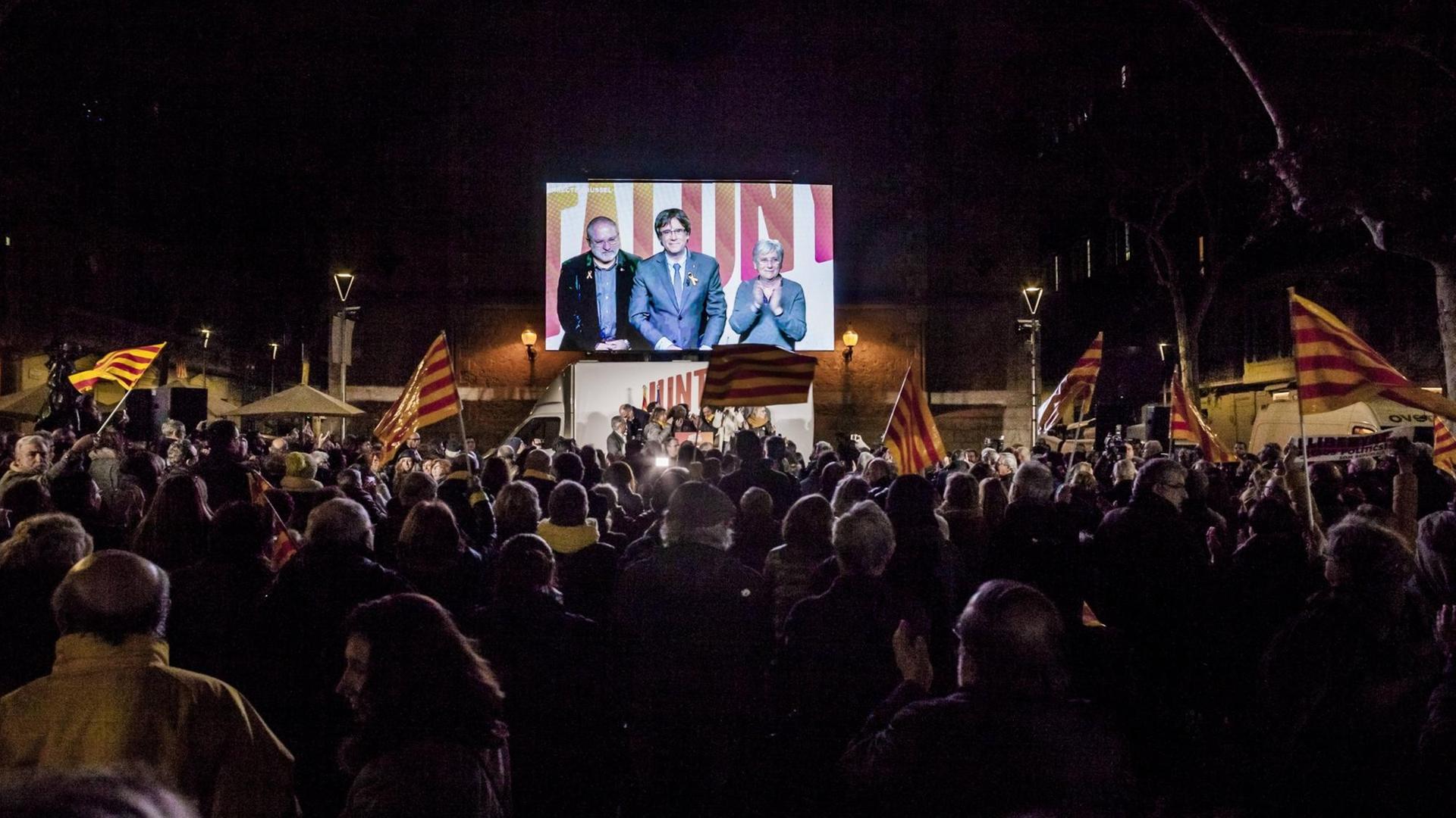 Der abgesetzte katalanische Regierungschef Carles Puigdemont ist auf einer Leinwand auf einer Kundgebung in Barcelona zu sehen. Er wurde zugeschaltet aus Brüssel, wseil in Spanien noch ein Haftbefehl gegen ihn vorliegt. Der abgesetzte katalanische Regierungschef Carles Puigdemont ist auf einer Leinwand auf einer Kundgebung in Barcelona zu sehen. Er wurde zugeschaltet aus Brüssel, wseil in Spanien noch ein Haftbefehl gegen ihn vorliegt.