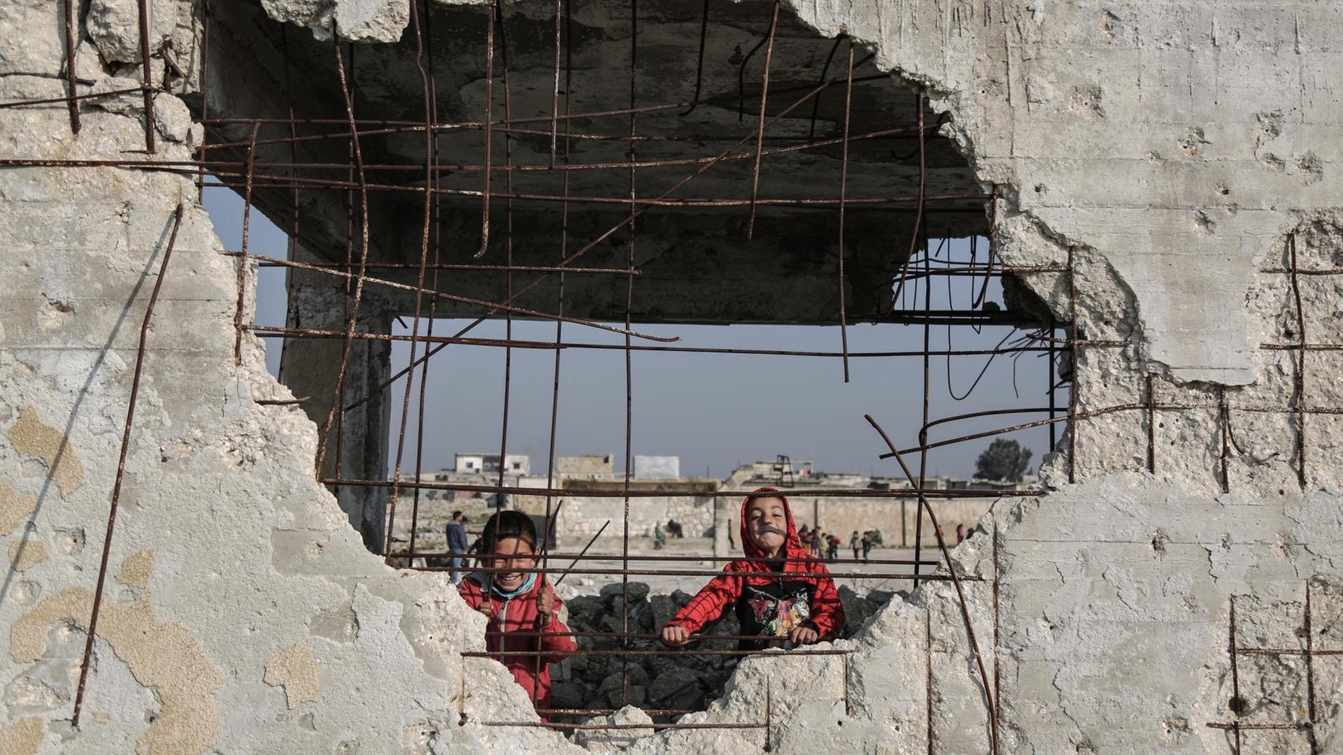 23.01.2019, Syrien, Jisr al-Shughur: Kinder spielen in den Trümmern der schwer beschädigten Al-Kefir-Schule. Mehr als 200 Schüler gehen hier immer noch zur Schule, obwohl Angriffe der syrischen Armee hier verheerende Spuren hinterlassen haben. 23.01.2019, Syrien, Jisr al-Shughur: Kinder spielen in den Trümmern der schwer beschädigten Al-Kefir-Schule. Mehr als 200 Schüler gehen hier immer noch zur Schule, obwohl Angriffe der syrischen Armee hier verheerende Spuren hinterlassen haben.