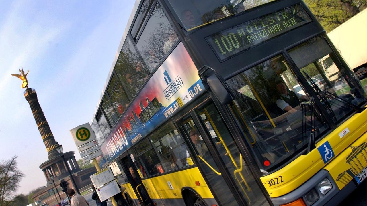 Auf dem Foto ist ein gelber Doppeldecker-Bus der Linie 100 zu sehen. Er verbindet den Westen mit dem Osten Berlins. Im Hintergrund ist die Siegessäule zu sehen. Auf dem Foto ist ein gelber Doppeldecker-Bus der Linie 100 zu sehen. Er verbindet den Westen mit dem Osten Berlins. Im Hintergrund ist die Siegessäule zu sehen.