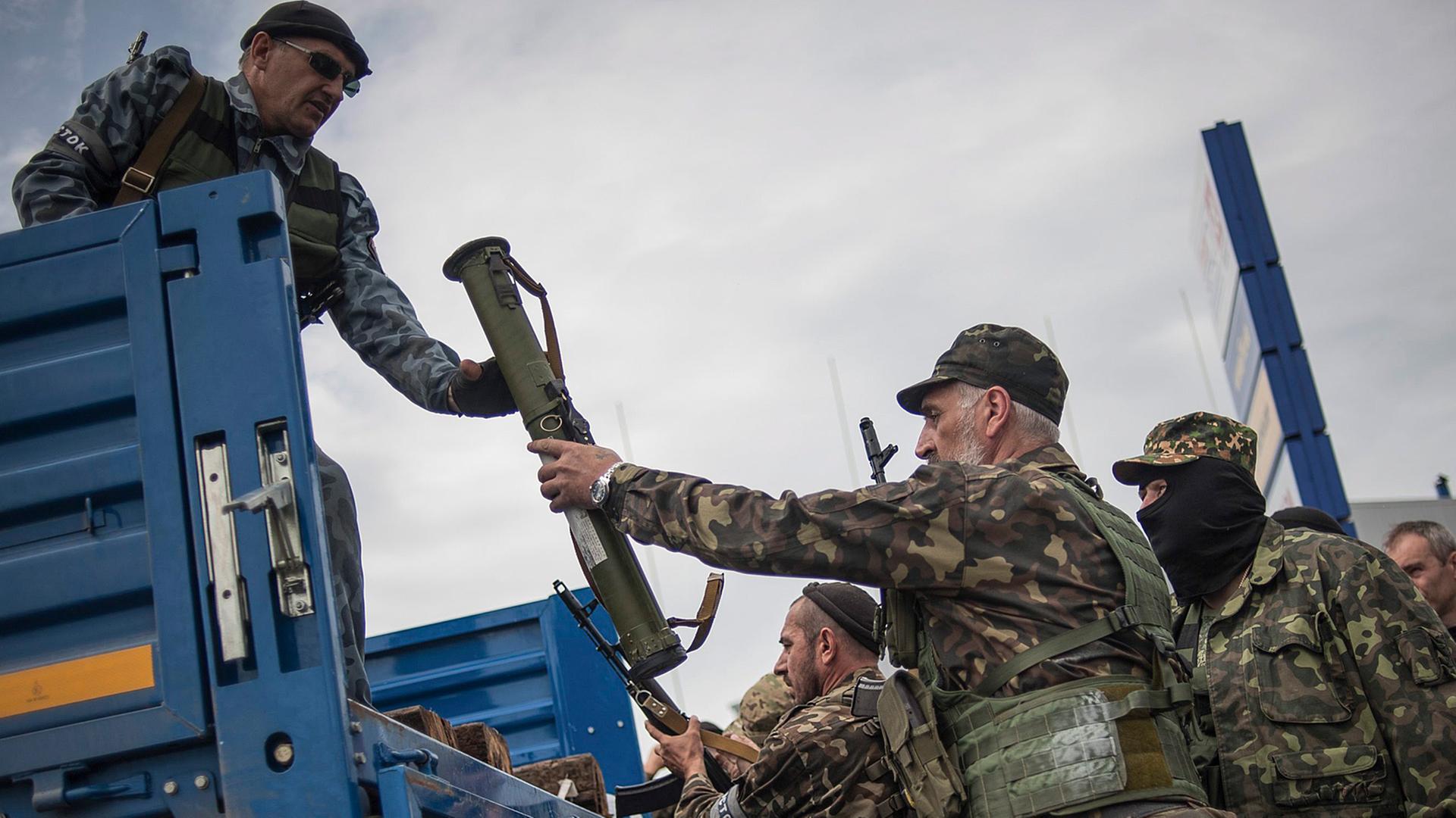 Pro-russische Aktivisten laden Waffen auf einen Truck, nachdem sie sich Gefechte mit ukrainischen Soldaten vor Donetsk geliefert haben. Pro-russische Aktivisten laden Waffen auf einen Truck, nachdem sie sich Gefechte mit ukrainischen Soldaten vor Donetsk geliefert haben.