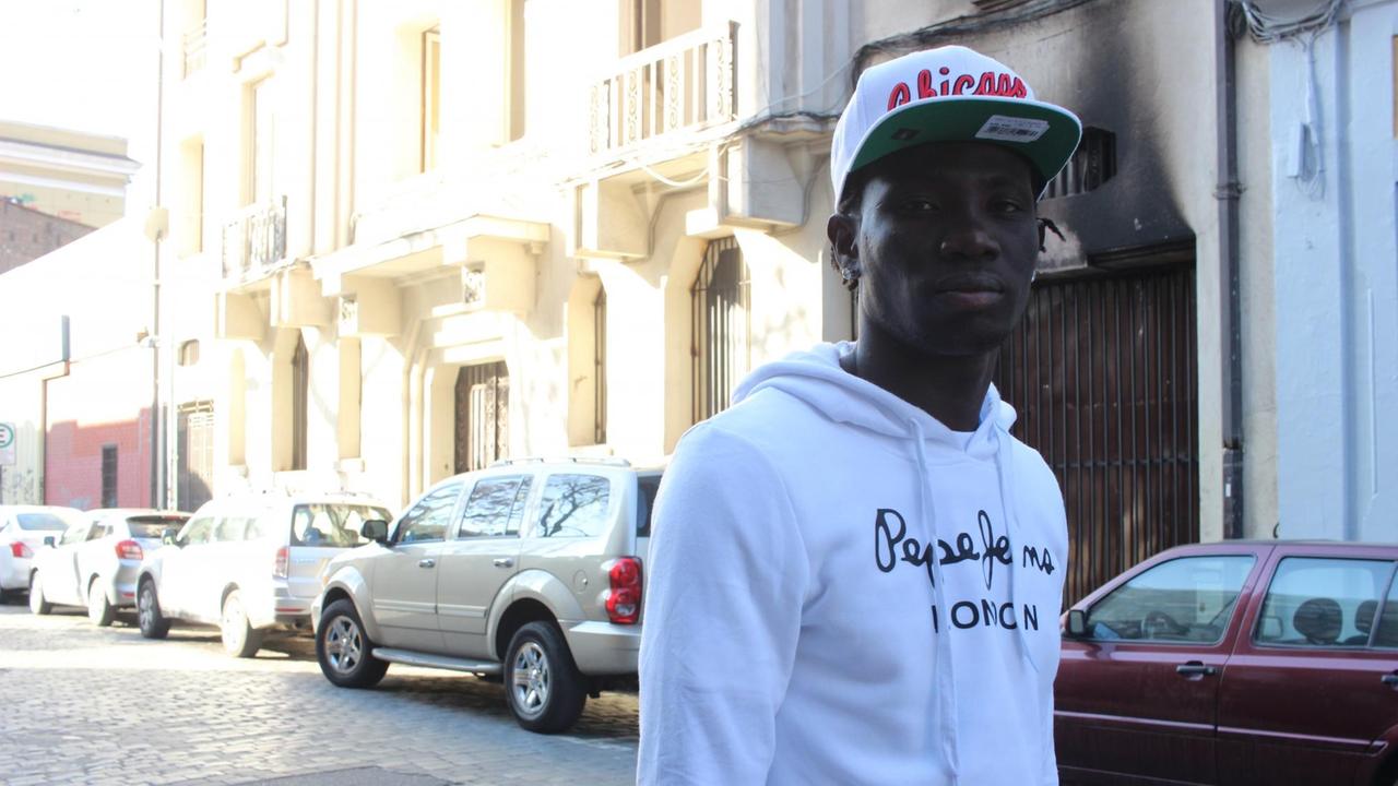 Junger Haitianer mit Käppi steht in einer schmalen Straße Junger Haitianer mit Käppi steht in einer schmalen Straße