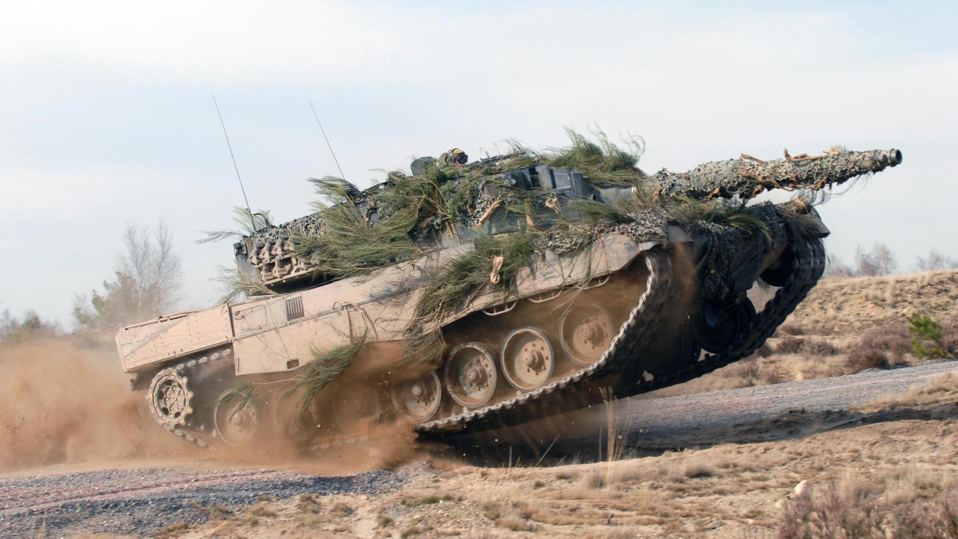 Kampfpanzer vom Typ Leopard 2 in voller Fahrt auf einem Testgelände Kampfpanzer vom Typ Leopard 2 in voller Fahrt auf einem Testgelände