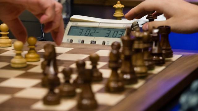 Zwei Schachspieler spielen am 14.10.2015 bei der Blitzschach-Weltmeisterschaft in Berlin an einem Brett. Beim Blitzschach hat jeder Spieler drei Minuten Zeit für seine Züge. Foto: Gregor Fischer/dpa | Verwendung weltweit