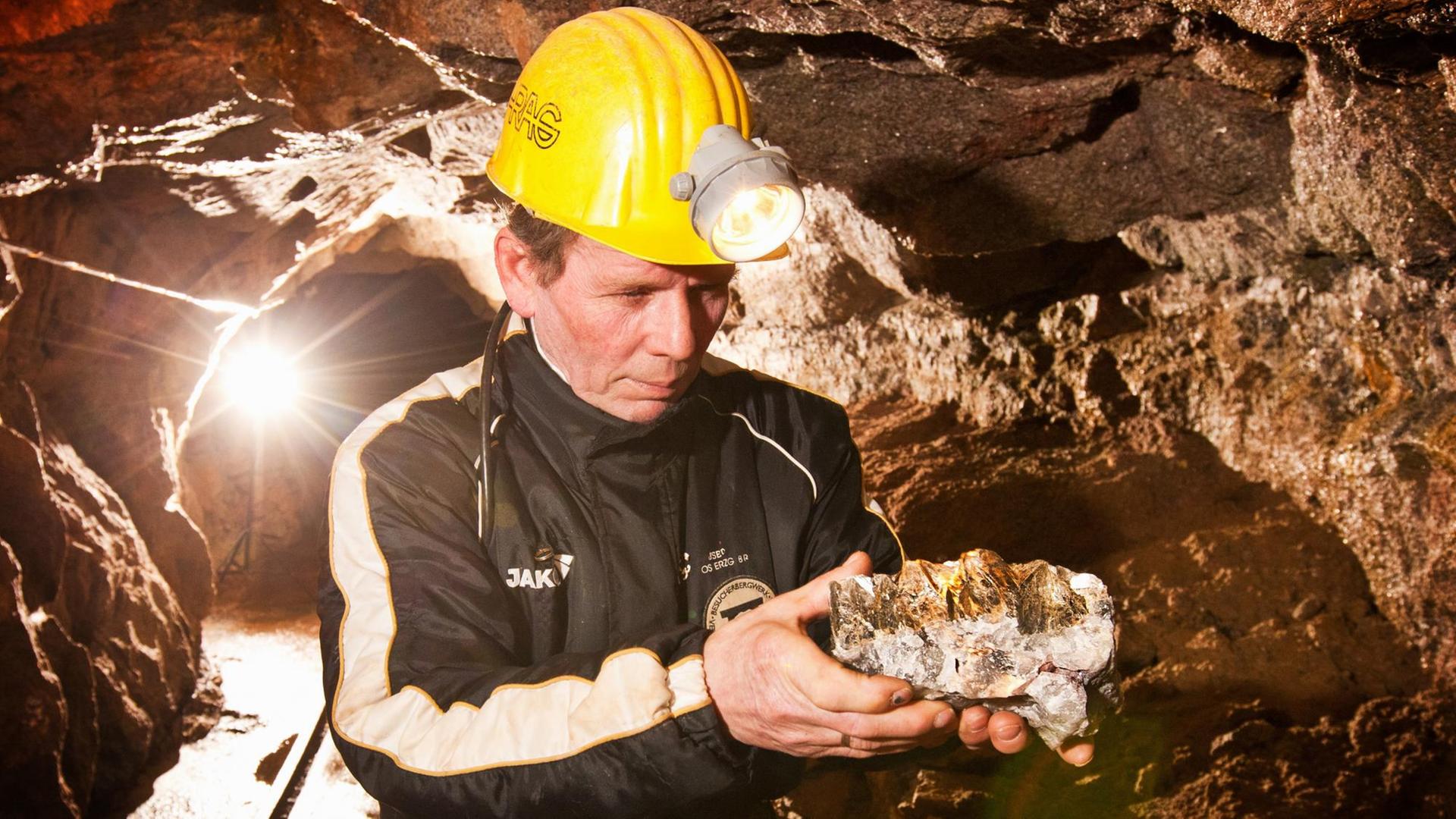 Ein Bergmann zeigt im einem Bergwerk im Erzgebirge einen Gesteinsbrocken mit Lithium. Ein Bergmann zeigt im einem Bergwerk im Erzgebirge einen Gesteinsbrocken mit Lithium.