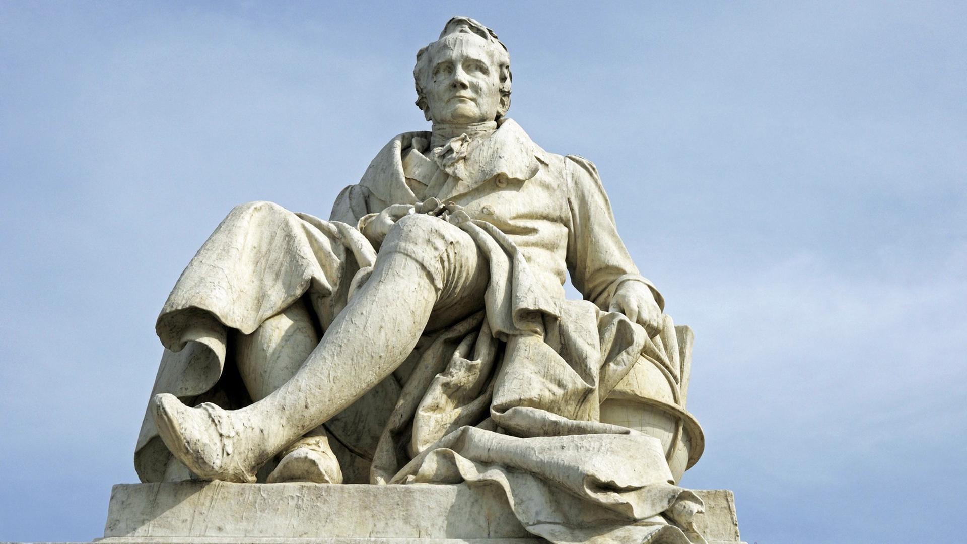 Blick auf die Statue des Denkmals Alexanders von Humboldt in Berlin gegen den Himmel Blick auf die Statue des Denkmals Alexanders von Humboldt in Berlin gegen den Himmel