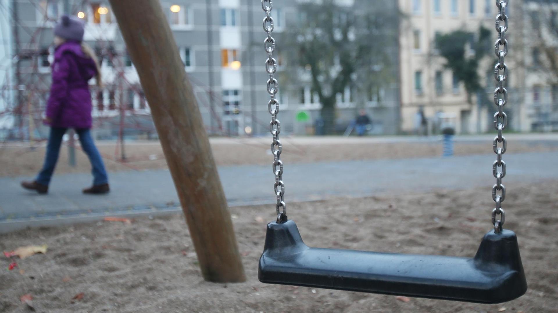 Eine Schaukel auf einem Spielplatz in Hamburg-Harburg - im Hintergrund geht ein Kind vorbei. Eine Schaukel auf einem Spielplatz in Hamburg-Harburg - im Hintergrund geht ein Kind vorbei.
