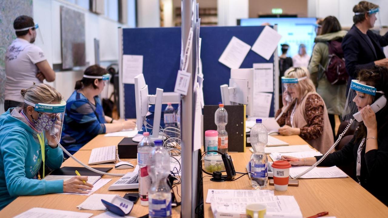 Mitarbeiter mit Gesichtsschutzschirm telefonieren im Lagezentrum des Gesundheitsamt Mitte. Das Gesundheitsamt Mitte führt eine neue Software-Lösung (Kontaktpersonen-Management-System SORMAS -Surveillance and Outbreak Response Management System) für die professionelle Verwaltung von Infektionsfällen ein Mitarbeiter mit Gesichtsschutzschirm telefonieren im Lagezentrum des Gesundheitsamt Mitte. Das Gesundheitsamt Mitte führt eine neue Software-Lösung (Kontaktpersonen-Management-System SORMAS -Surveillance and Outbreak Response Management System) für die professionelle Verwaltung von Infektionsfällen ein