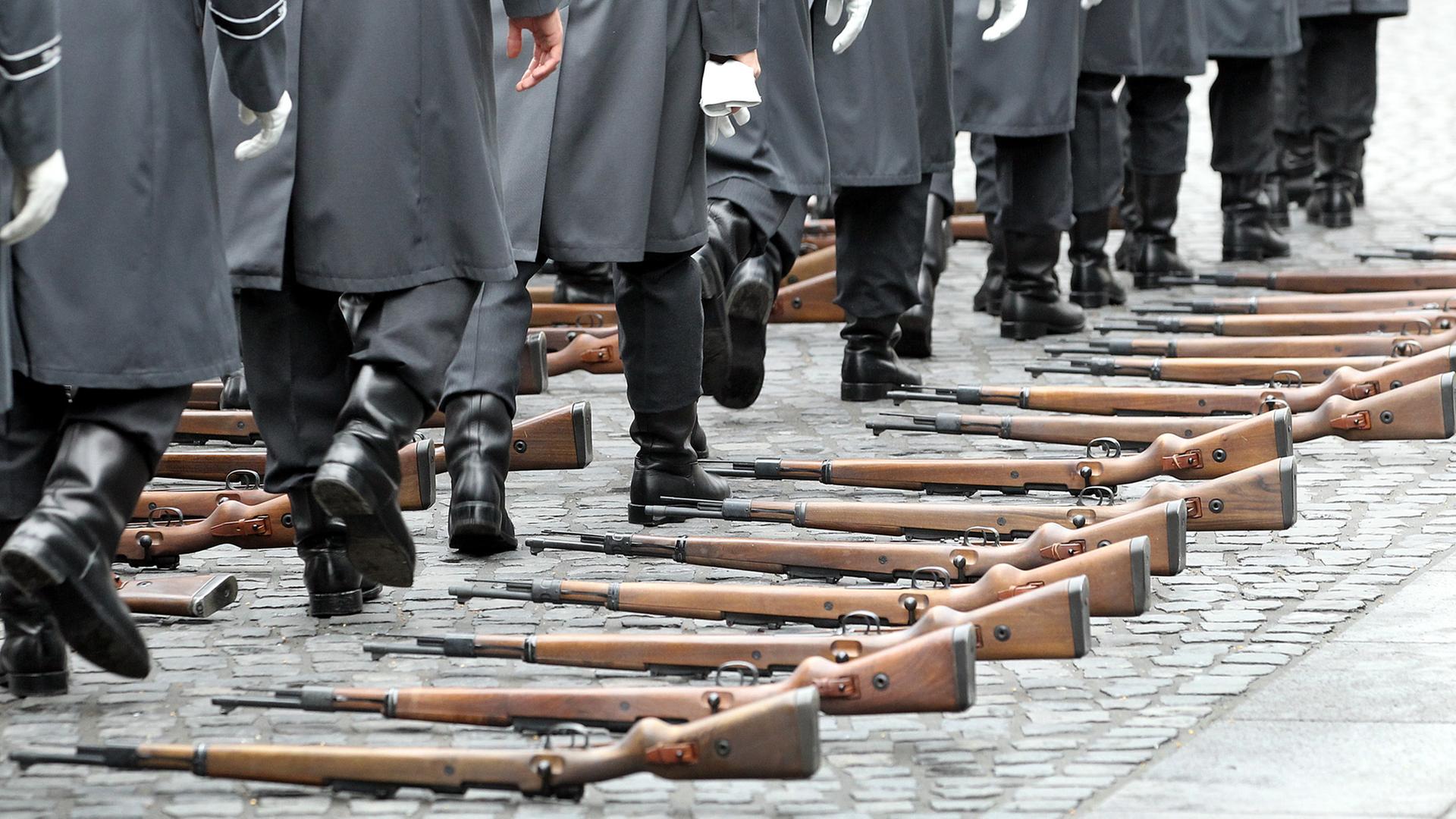Soldaten des Wachbataillons der Bundeswehr gehen am Schloss Bellevue in Berlin an ihren ausgelegten Gewehren vom Typ Karabiner 98 k vorbei. Soldaten des Wachbataillons der Bundeswehr gehen am Schloss Bellevue in Berlin an ihren ausgelegten Gewehren vom Typ Karabiner 98 k vorbei.