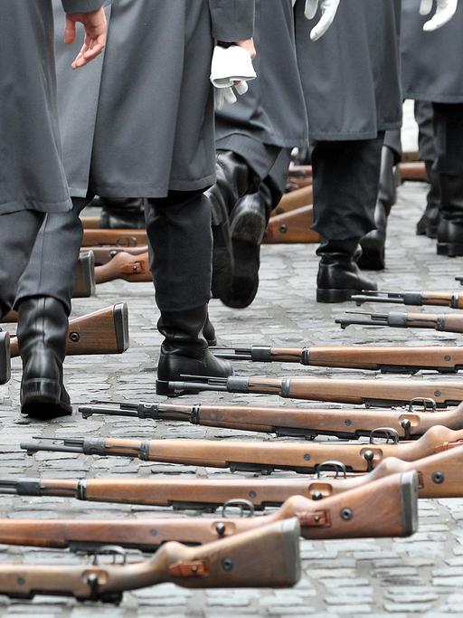 Soldaten des Wachbataillons der Bundeswehr gehen am Schloss Bellevue in Berlin an ihren ausgelegten Gewehren vom Typ Karabiner 98 k vorbei.