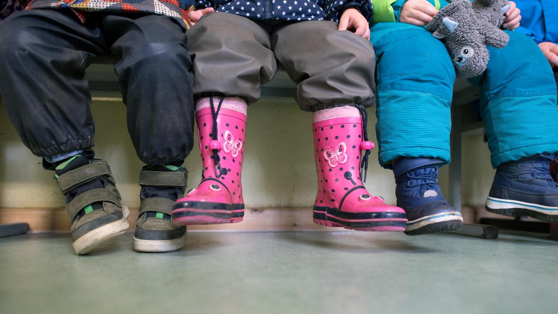 Kinder sitzen auf einer Bank in einer Kindertagesstätte. Kinder sitzen auf einer Bank in einer Kindertagesstätte.