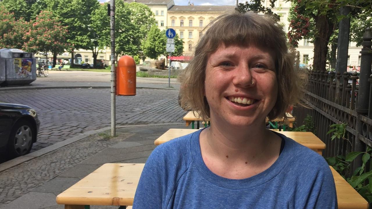 Susanna Raab von der Initiative "Deutsche Wohnen & Co. enteignen" sitzt an einem Tisch auf einer Berliner Straße. Susanna Raab von der Initiative "Deutsche Wohnen & Co. enteignen" sitzt an einem Tisch auf einer Berliner Straße.