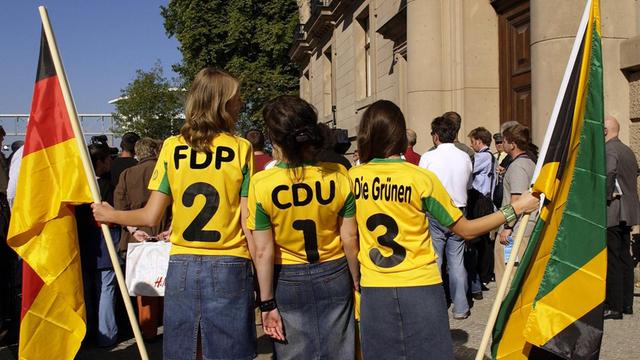 In Berlin wird über eine Jamaika-Koalition verhandelt: Parteien FDP, CDU und DIE GRÜNEN auf T-Shirts dreier Mädchen mit Fahnen in Berlin