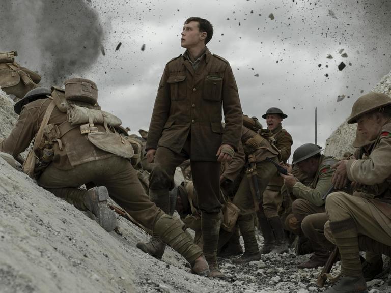 Filmszene aus "1917" von Sam Mendes: George MacKay als Soldat Schofield im Schützengraben, umgeben von anderen Soldaten.