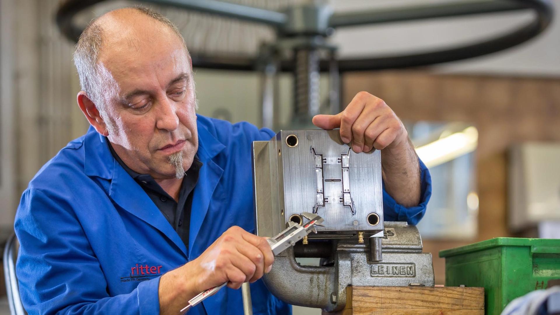 Älterer Arbeitnehmer am seinem Arbeitsplatz in einem Handwerk Älterer Arbeitnehmer am seinem Arbeitsplatz in einem Handwerk
