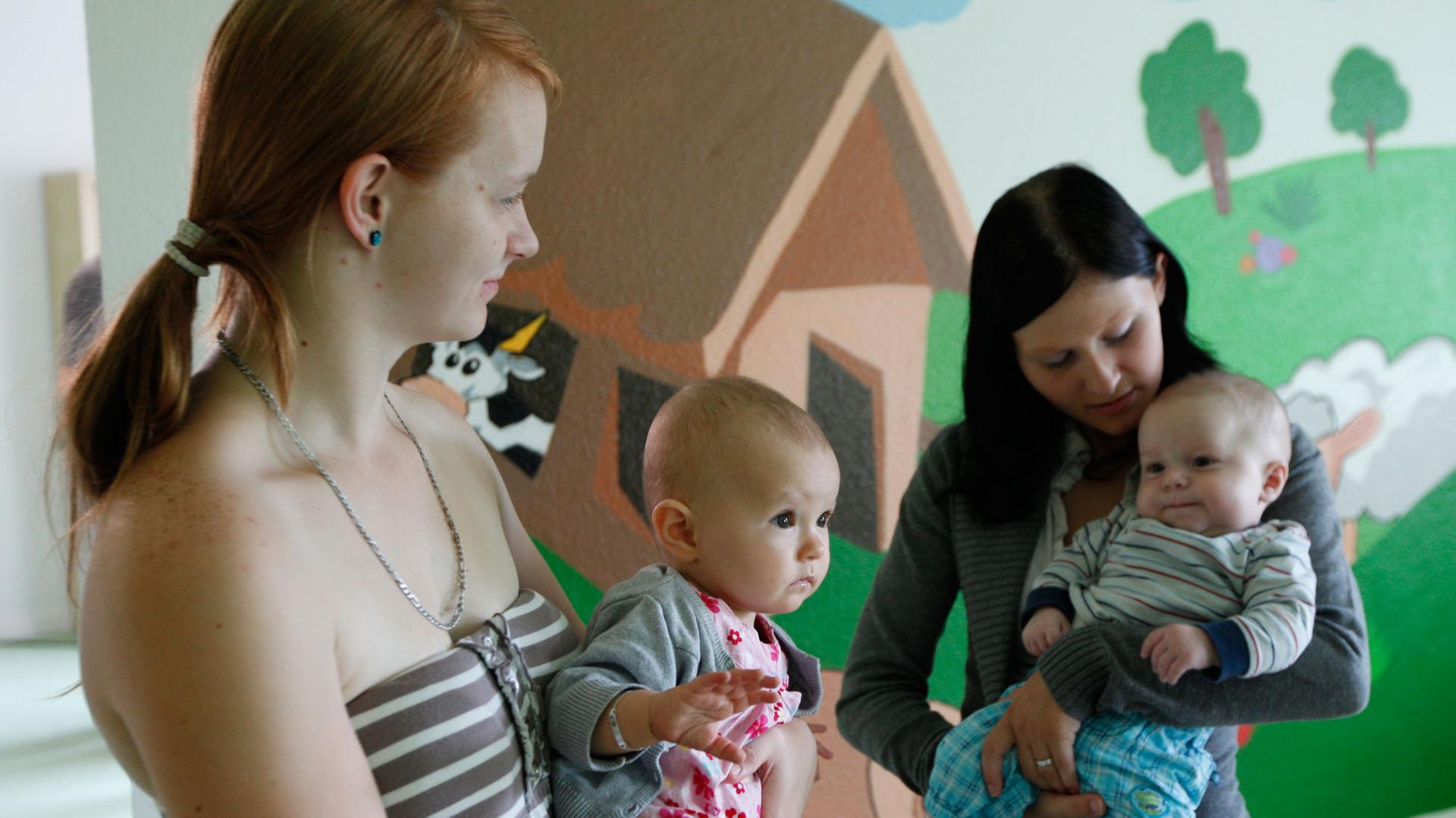 Zwei Mütter mit ihren kleinen Kindern Zwei Mütter mit ihren kleinen Kindern