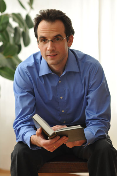 Nicolai Sinai mit einem aufgeschlagenen Buch. Nicolai Sinai mit einem aufgeschlagenen Buch.