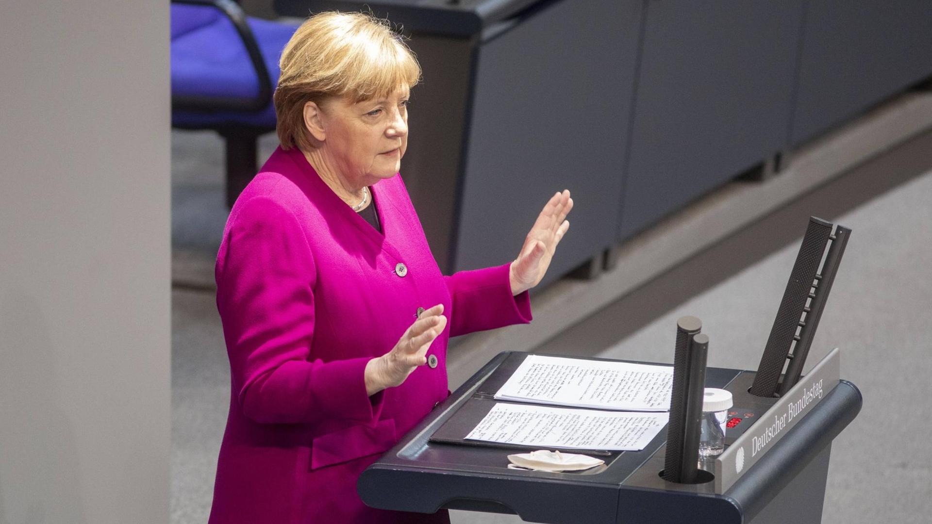 Angela Merkel steht am Rednerpult im Bundestag und spricht, beide Hände leicht erhoben Angela Merkel steht am Rednerpult im Bundestag und spricht, beide Hände leicht erhoben