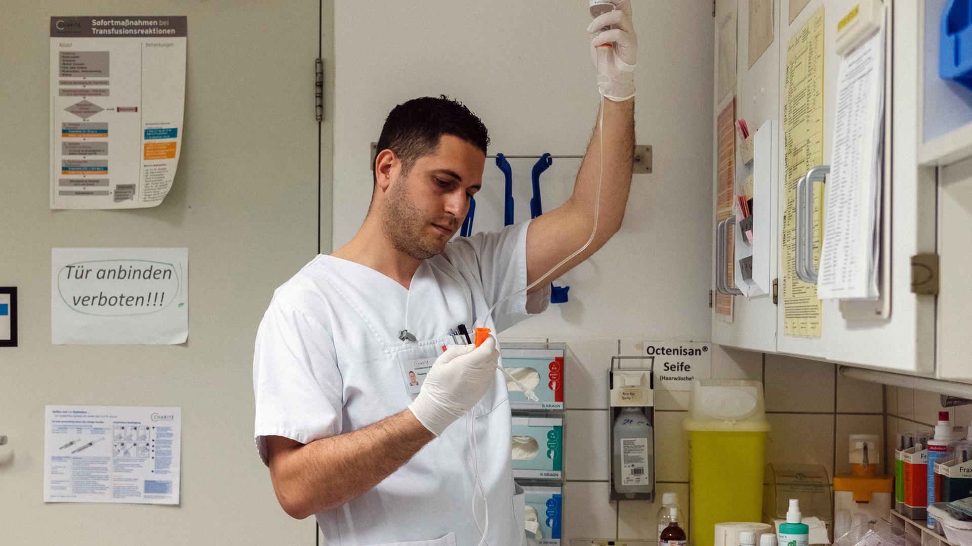 Der albanische Krankenpfleger Samed Qoshja bereitet in der Neurochirurgie der Charité am Campus Benjamin Franklin eine Infusion vor. Der albanische Krankenpfleger Samed Qoshja bereitet in der Neurochirurgie der Charité am Campus Benjamin Franklin eine Infusion vor.
