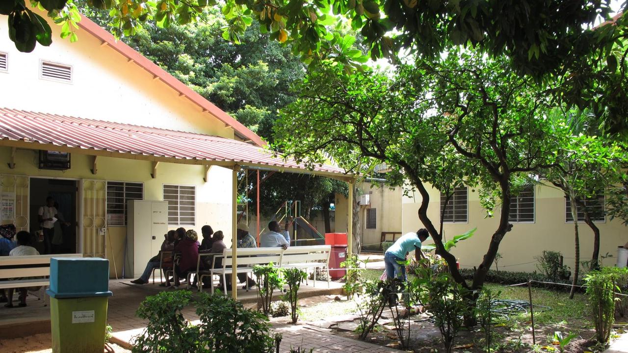 Die Tuberkulose-Station in Maputo, Mozambik - Patienten warten auf Bänken auf der Veranda des Gebäudes Die Tuberkulose-Station in Maputo, Mozambik - Patienten warten auf Bänken auf der Veranda des Gebäudes