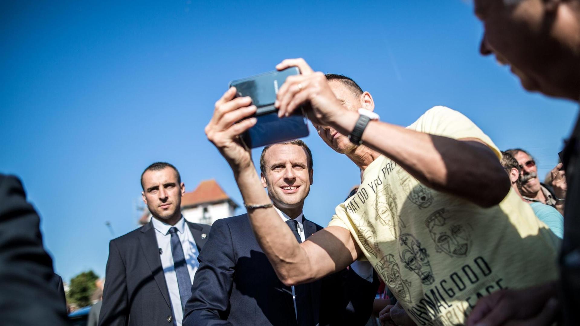 Der französische Präsident Emmanuel Macron (l.) hat seine Stimme bei der zweiten Runde der Parlamentswahl in Le Touquet am Ärmelkanal abgegeben. Anschließend machte er Fotos mit Anhängern.