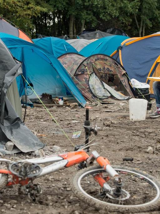 Ein Flüchtling inmitten von Zelten im Flüchtlingslager von Calais.